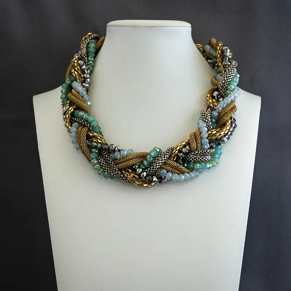 a statement necklace features six strands artfully intertwined into one dynamic design. Combining two polished gold-tone strands, one sleek silver strand, and three shimmering strands of faceted glass