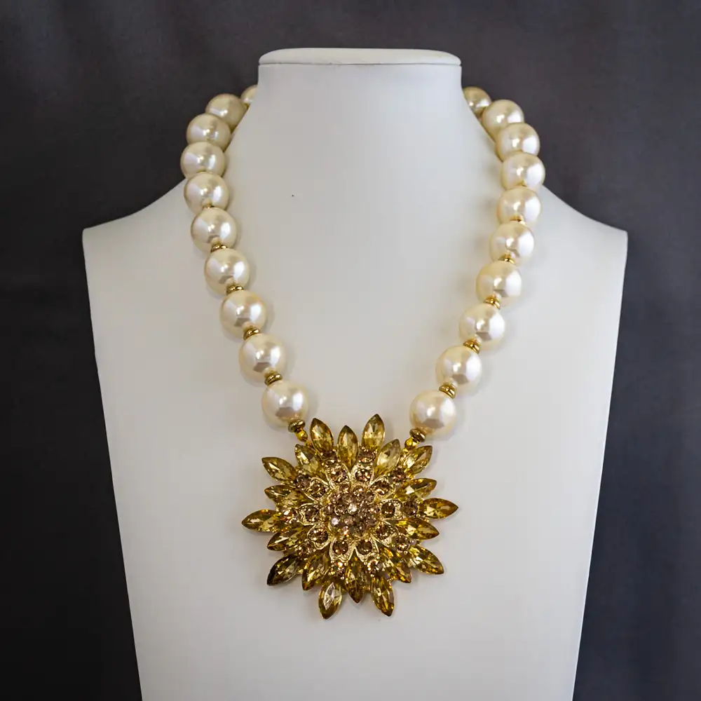 necklace showcases a new 2.75-inch statement pendant, dazzling with light gold rhinestones in a variety of dynamic shapes and sizes.