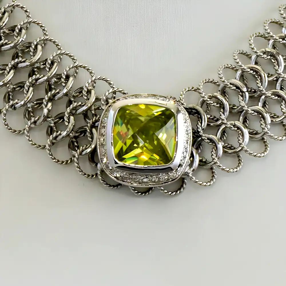 Close up of a 16-inch necklace features a band of intricately intertwined smooth and textured silver-tone rings.