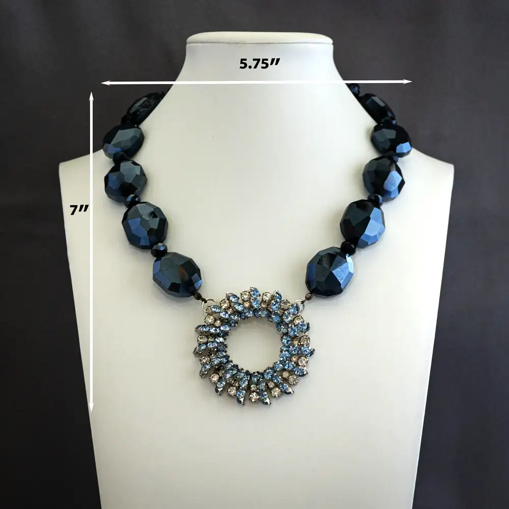 Dimensions of an elegant necklace features a vintage 2-inch circular pendant filled with a sparkling mix of pale blue and clear rhinestones.