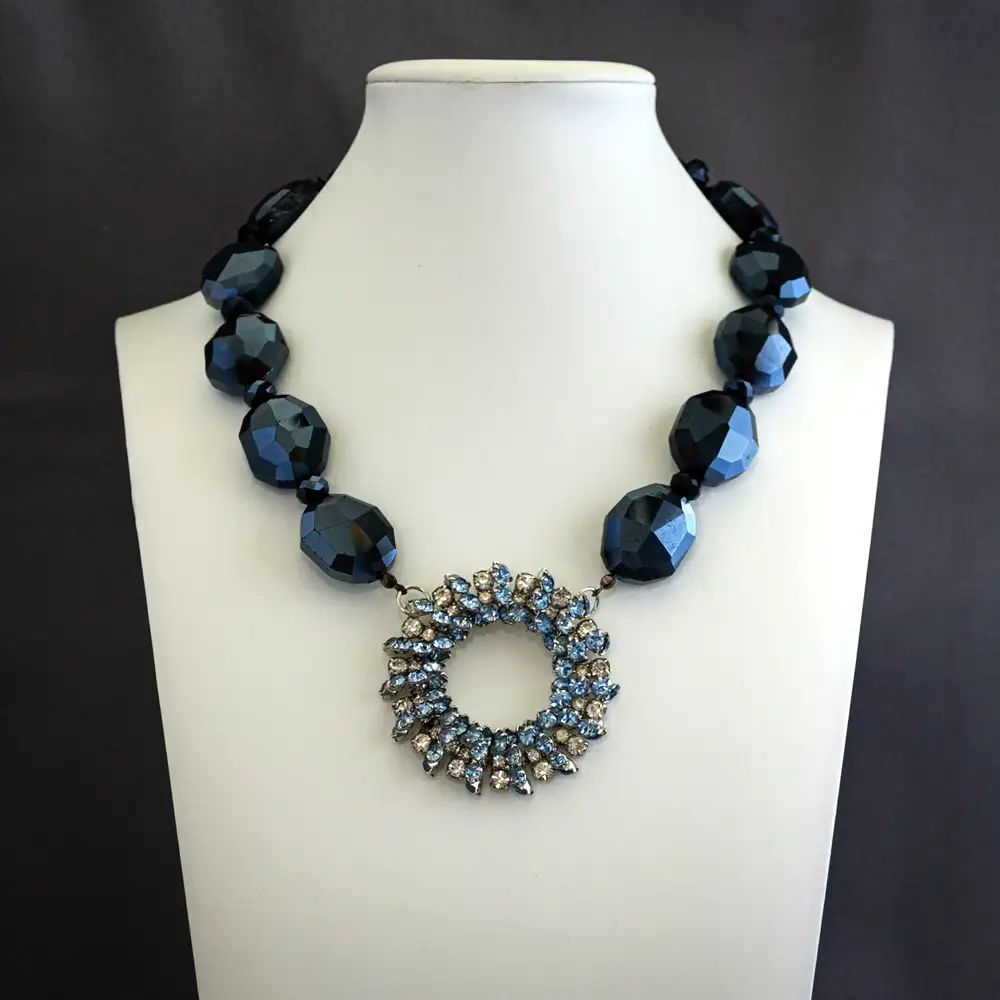 elegant necklace features a vintage 2-inch circular pendant filled with a sparkling mix of pale blue and clear rhinestones.