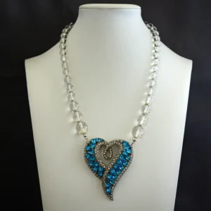 this statement necklace centers on a stylized heart pendant (2′′ wide×2.5′′ long) featuring vibrant turquoise framed by brilliant clear rhinestones.