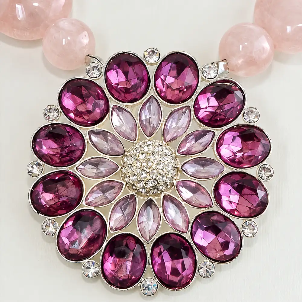 Close up of statement necklace. Soft, opaque rose quartz beads rhythmically alternate in 10mm and 18mm sizes for dynamic, eye-catching dimension.