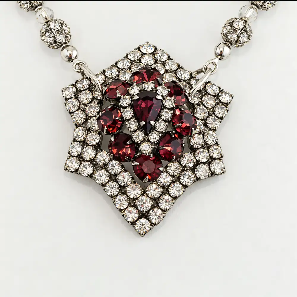 A vintage slight six-point star pendant, adorned with vibrant raspberry and clear rhinestones, serves as the captivating centerpiece.