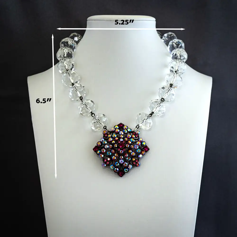 Dimensions of a vintage 15.5-inch necklace features a signed Joan Rivers filigree pendant set with mesmerizing pink and purple aurora borealis rhinestones that catch the light with brilliant color.