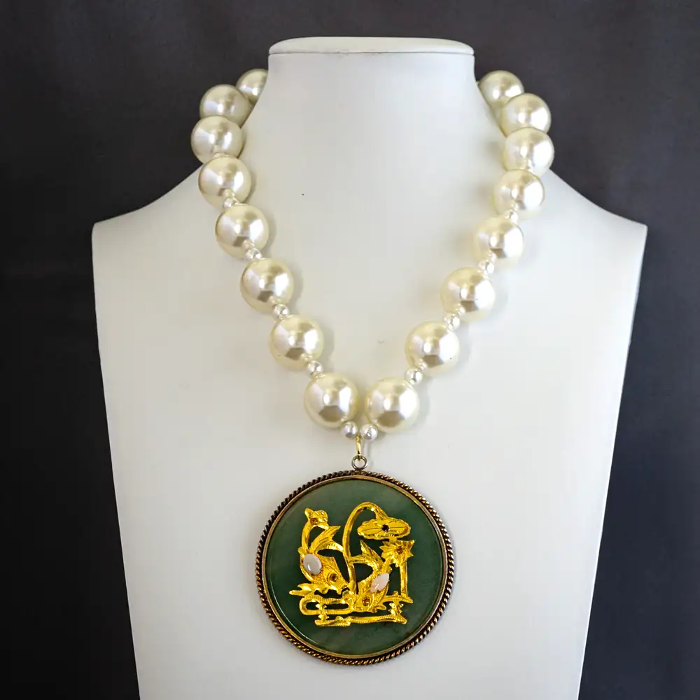 vintage statement necklace centers on a remarkable 2.5" light green jade medallion, featuring a gold-tone applique set with two small opals and five sparkling rhinestones.