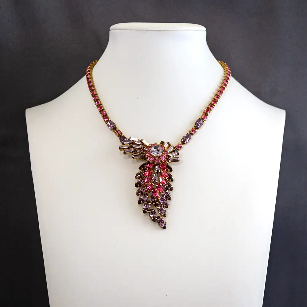 This vintage 16-inch necklace features a charming band set with bright pink and lavender rhinestones.