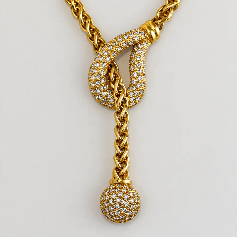 Close up of a 17-inch vintage Traci Lynn lariat necklace features a bright gold-tone chain complemented by a half-globe pendant with an elegant 3.5-inch drop.