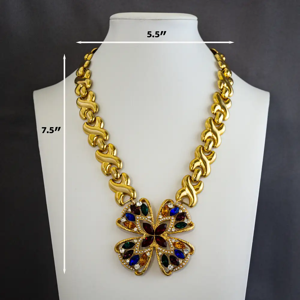 this statement necklace centers on a brilliant 2.375” round pendant adorned with multi-colored rhinestones and delicate faux seed pearls.