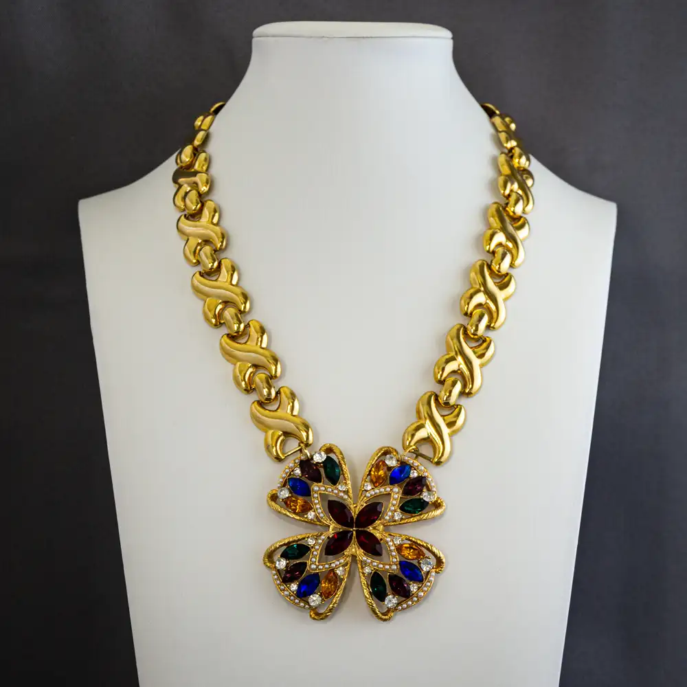 this statement necklace centers on a brilliant 2.375” round pendant adorned with multi-colored rhinestones and delicate faux seed pearls.