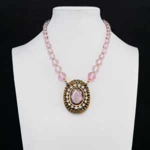a romantic statement necklace features a strand of faceted light pink glass beads that reflect a soft, luminous sparkle.