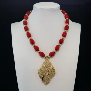 bold vintage necklace showcases vibrant red oval beads separated by polished gold-tone accent beads.