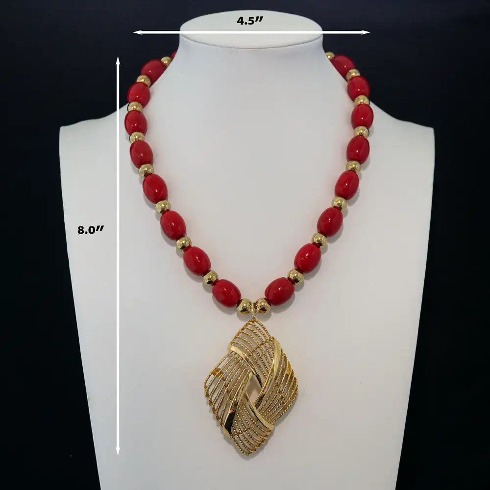 description of a bold vintage necklace showcases vibrant red oval beads separated by polished gold-tone accent beads.