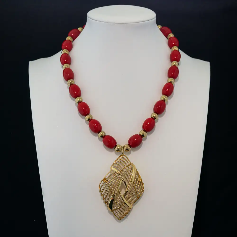 bold vintage necklace showcases vibrant red oval beads separated by polished gold-tone accent beads.