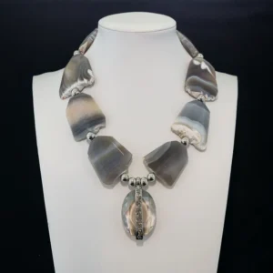 striking necklace features large, organic slabs of natural grey and white banded agate separated by polished silver-tone accent beads.