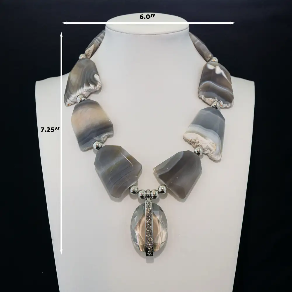 description of a striking necklace features large, organic slabs of natural grey and white banded agate separated by polished silver-tone accent beads.