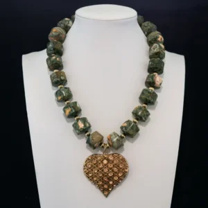This bold necklace features natural, barrel-shaped leopard skin jasper beads in earthy green and peach tones, accented by small gold spacers.