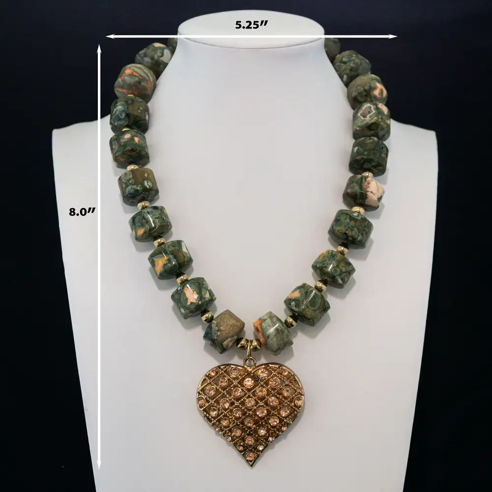 Dimensions of a bold necklace features natural, barrel-shaped leopard skin jasper beads in earthy green and peach tones, accented by small gold spacers.