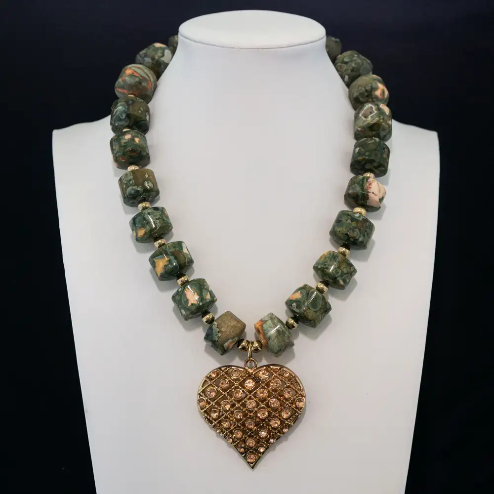 This bold necklace features natural, barrel-shaped leopard skin jasper beads in earthy green and peach tones, accented by small gold spacers.