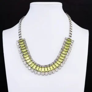 This dazzling vintage statement necklace features a striking band of baguette-cut, peridot-green rhinestones set in a silver-tone frame.